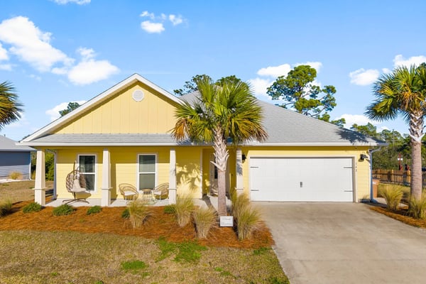 Coastal beach house exterior with palm trees at dusk